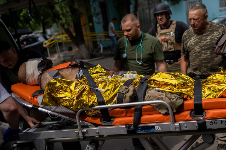 An injured Ukrainian serviceman is evacuated to a hospital in the Donetsk region, eastern Ukraine, Sunday, June 5, 2022
