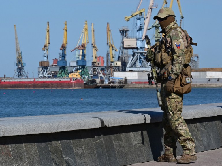 A Russian serviceman patrols on the promenade in Berdyansk.