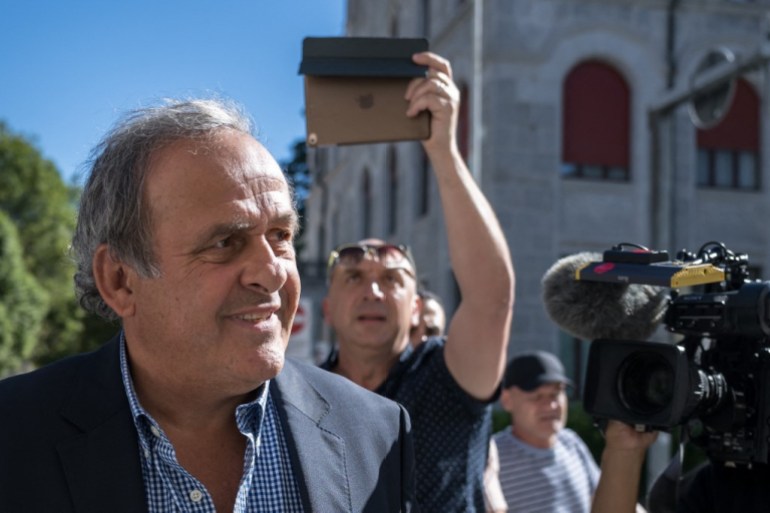 Platini (L), surrounded by journalists