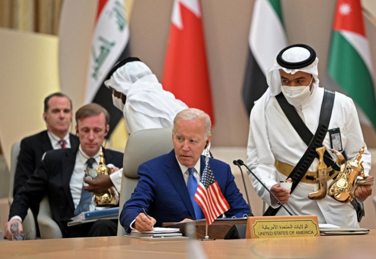 US President Joe Biden takes notes as he attends the Jeddah Security and Development Summit 