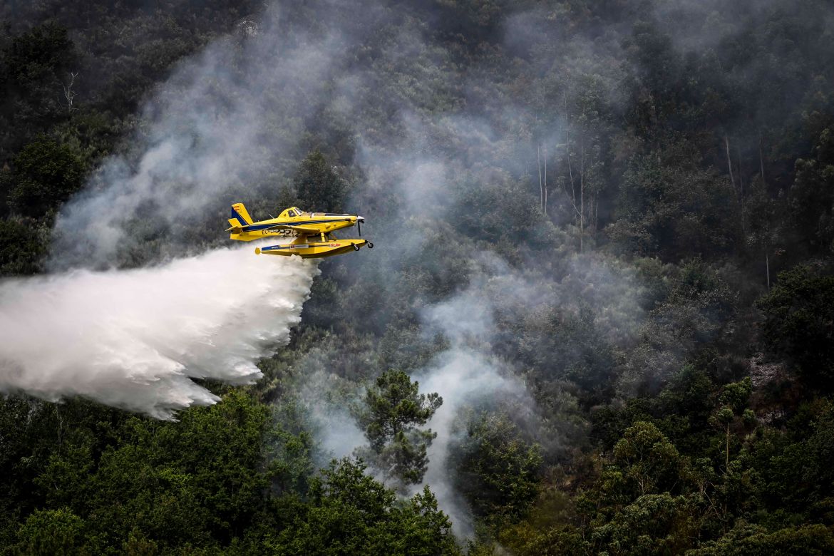 A firefighter aircraft Air Tractor AT-802F Fire Boss drops water in a wildfire near Bustelo, east of Amarante, north of Portugal
