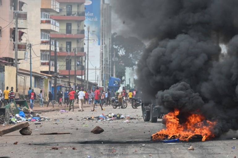 Black smoke billows into the air from a fire set during protests on the streets of Conakry, Guinea.