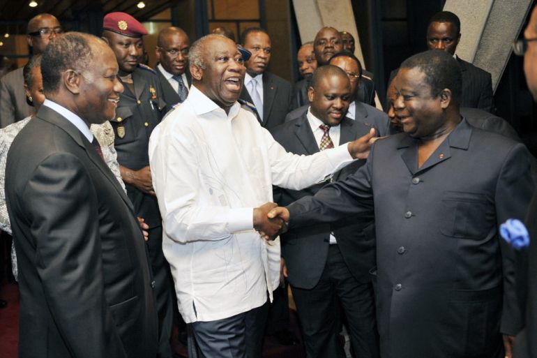 Current Ivorian president Alassane Dramane Ouattara (L) views the then president Laurent Gbagbo (C) shaking hands with another former President Henri Konan Bedie during a meeting held at the presidential palace in Abidjan on June 30, 2010