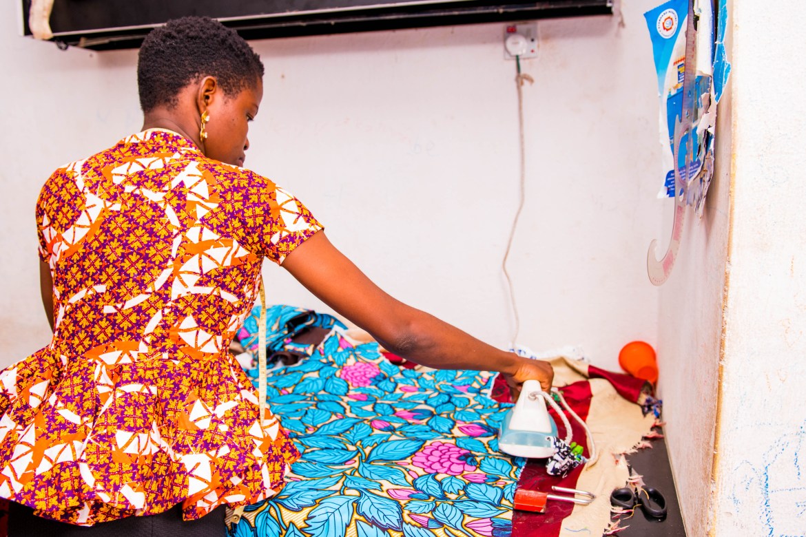 In her shop, Bunmi prepares a garment for a client. One of her concerns as a business owner is that most of her clients are unable to pay the full price she charges for custom designs. “In Minna, we have 50 percent of people who are civil servants, earning their salary at the end of the month. If you produce work for them, you’ll wait until the end of the month before they will pay you. And some are low-income earners, so they will pay only part of the money…”