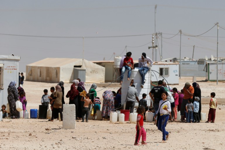Syrian refugees collect water at the Al-Zaatari refugee camp in Mafraq, Jordan