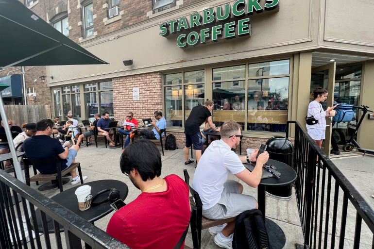 People crowd around a Toronto Starbucks amid a Rogers network outage