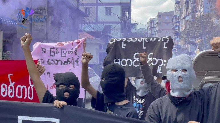 Prosters in black balaclavas march on the street in Yangon following the execution of four pro-democracy activists and politicians.