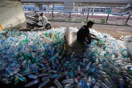 An Indian worker sorts used plastic bottles before sending them to be recycled, at a railway station on World Environment Day in Ahmadabad, India in 2018 [Ajit Solanki/AP]