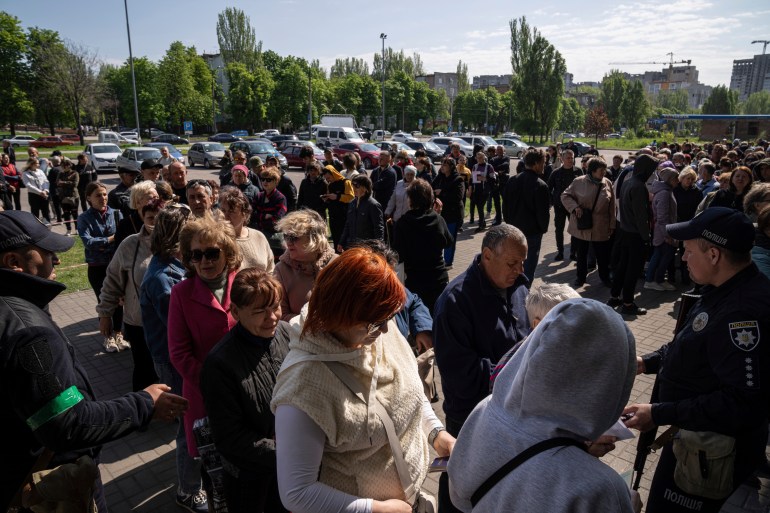 People stand in line for registration at the aid distribution center for displaced people in Zaporizhia, Ukraine