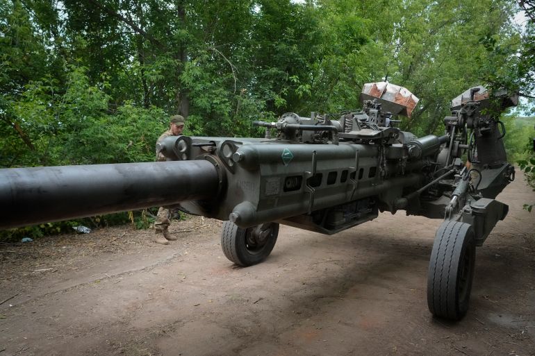 Ukrainian soldiers move a U.S.-supplied M777 howitzer into position to fire at Russian positions in Ukraine's eastern Donetsk region