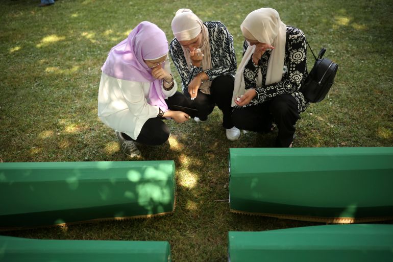 Bosnian women mourn next to the coffin