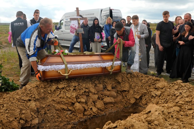 Men lower the coffin of Liza, 4-year-old girl killed by Russian attack, during a funeral ceremony in Vinnytsia