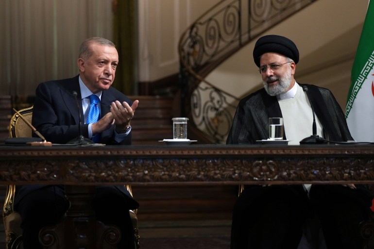 Turkish President Recep Tayyip Erdogan claps as Iranian President Ebrahim Raisi concludes his speech during their joint press briefing at the Saadabad Palace, in Tehran.