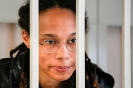 Griner, from shoulders up, behind white bars