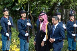 Greece's Prime Minister Kyriakos Mitsotakis, right, escorts Saudi Crown Prince Mohammed bin Salman as they inspect a guard of honour, in Athens