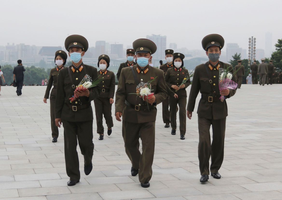 North Korean military personnel visit the statues of former North Korean leaders Kim Il Sung and Kim Jong Il