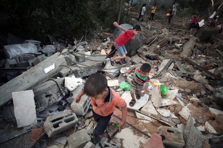 Palestinian children walk in the rubble of a house destroyed by an Israeli strike, in the town of Beit Hanoun, northern Gaza Strip in 2014