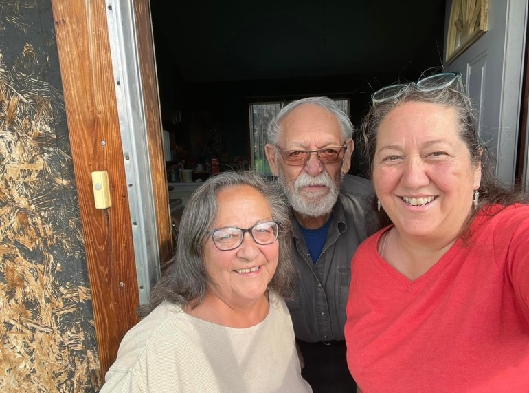 A photo of Christi Belcourt standing next to Murleen Letendre Crossen and Bob Belcourt.