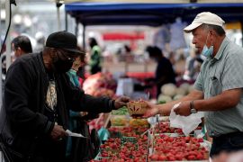 A resident buys strawberries at a local market, in downtown San Francisco, California, U.S.