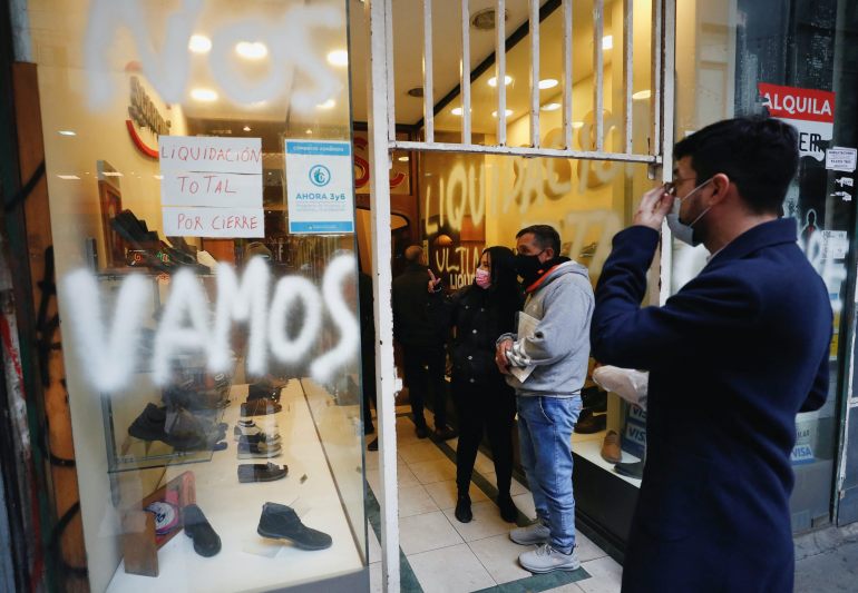 People watch a store closing down sale in downtown Buenos Aires, Argentina