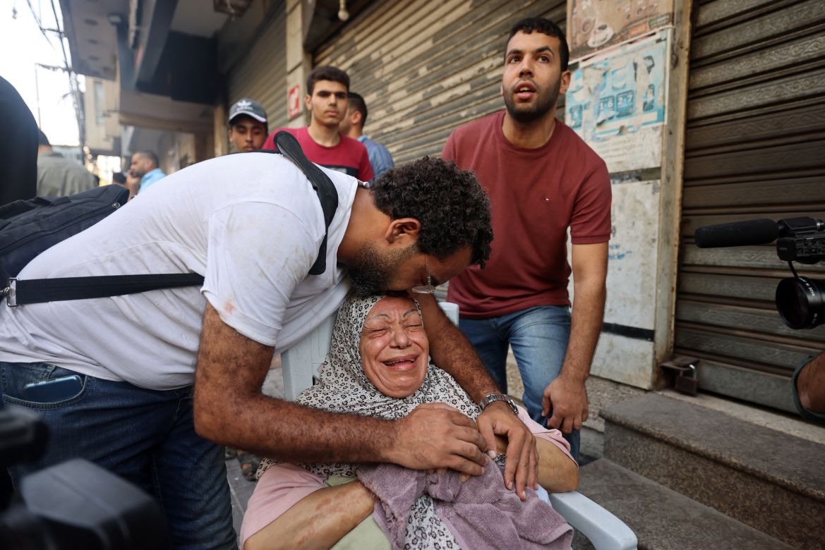 A relative comforts an injured Palestinian woman in Gaza City.