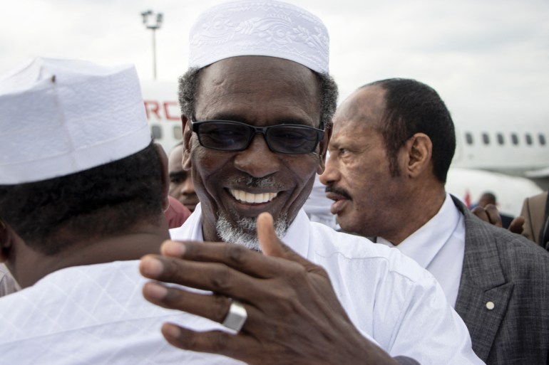 Timan Erdimi (C), leader of the rebel Union of Resistance Forces (UFR), greets his relatives who came to welcome him as he arrives at the N'Djamena International Airport in N'Djamena, Chad, on August 18, 2022, after 17 years in exile. - Timan Erdimi, the head of the Union of Resistance Forces (UFR), has been living in exile in Qatar for at least a decade, after his rebel group attempted to overthrow former Chadian president Idriss Deby Itno, first in 2008 and again in 2019.