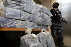 A Romanian special forces unit member stands guard near bags containing part of 2.5 tonnes of cocaine seized in the Black Sea port of Constanta