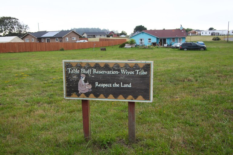 A photo of a sign on a grass lawn that says "Table Bluff Reservation- Wiyot Tribe, Respect the Land".