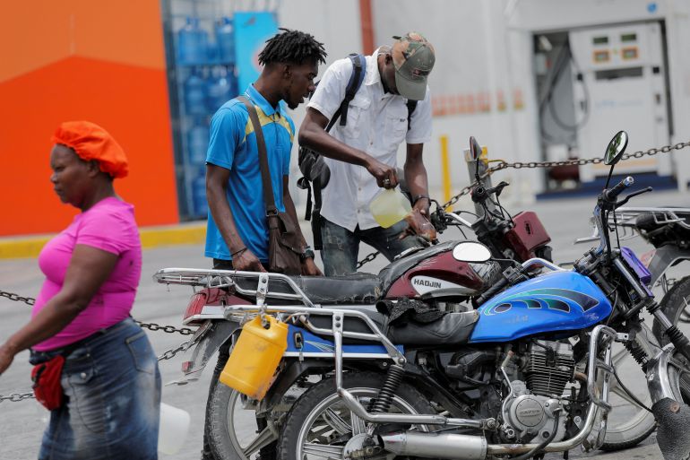 A man fills the tank of his motorcycle with fuel in Port-au-Prince