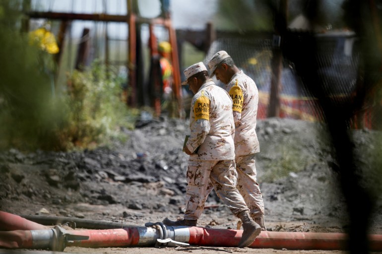 Soldiers walk near the area of a rescue operation for miners trapped in a coal mine that flooded in Sabinas, Coahuila state, Mexico.
