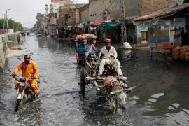 A man rides on donkey cart through a water-filled street in Jacobabad, Pakistan.