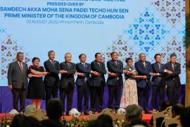 Asean foreign ministers standing on stage at their meeting in Phnom Penh