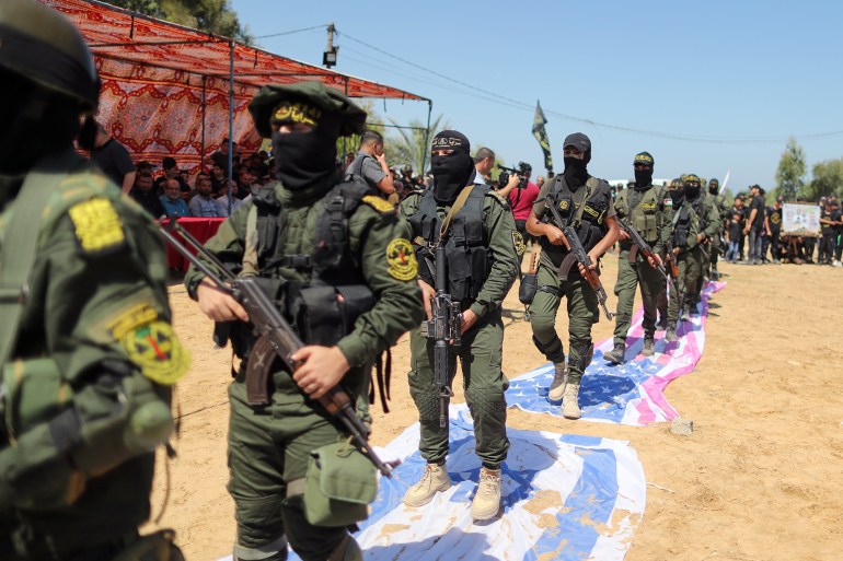 Palestinian Islamic Jihad militants step on replicas of Israeli and U.S. flags during a graduation ceremony for young Palestinians at a military camp organised by the movement, in Gaza City, June 30, 2021.