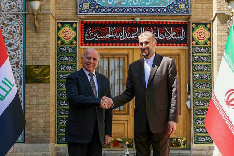 Iraqi foreign minister Fuad Hussein, left, shakes hands with his Iranian counterpart Hossein Amirabdollahian in Tehran, Iran [File: Handout by Iranian foreign ministry]