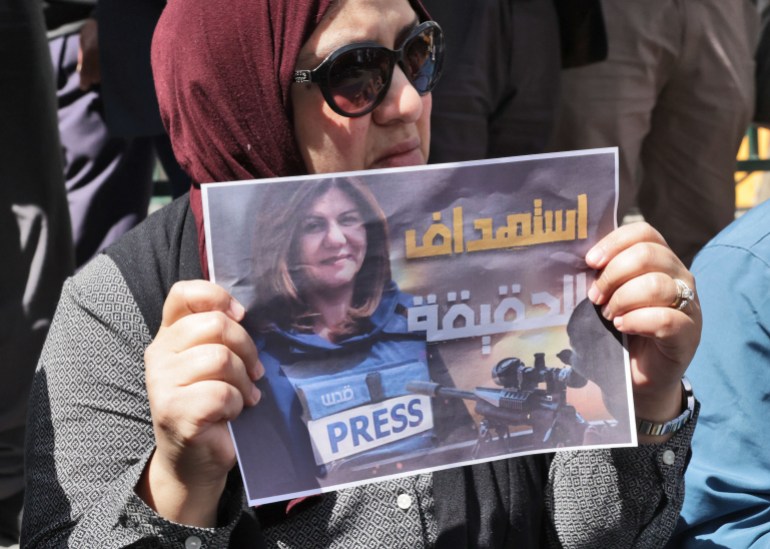 Palestinians hold posters displaying veteran Al Jazeera journalist Shireen Abu Aqleh (Akleh), who was shot dead as she covered a raid on the West Bank's Jenin refugee camp on May 11, 2022, in the West Bank city of Hebron.