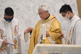 Cardinal Zen, dressed in golden robes and flanked by two others, leads a mass in Hong Kong in May, a few days after his arrest