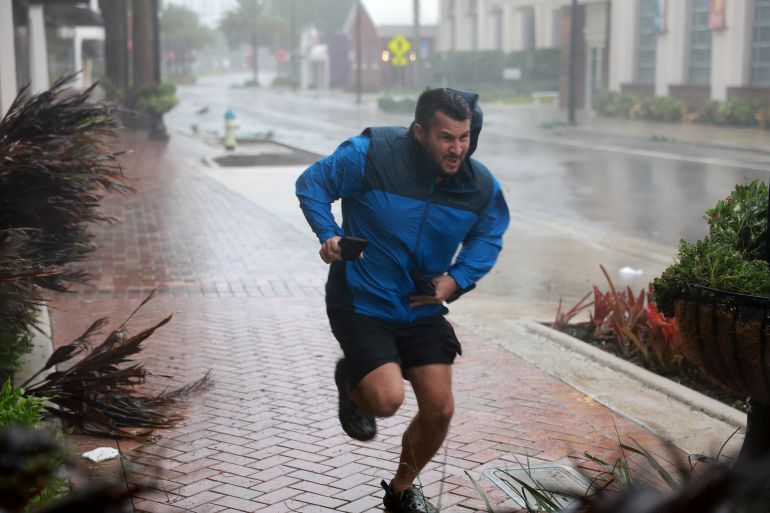 A man tries to run amid the wind and rain of Hurricane Ian in Sarasota, Florida.