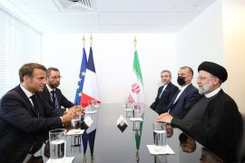 French President Emmanuel Macron, near left, and Iranian President Ebrahim Raisi, near right, meet at the sidelines of the UNGA