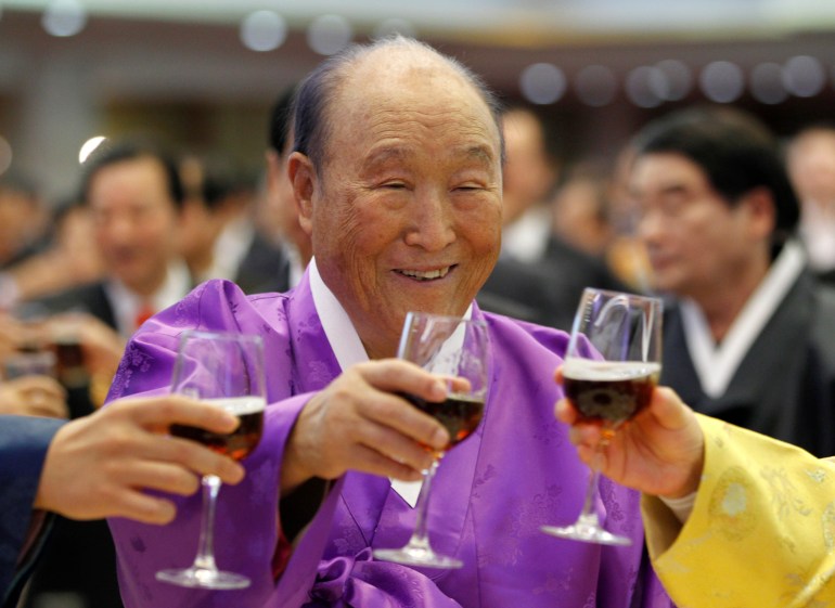Moon Sun Myung, the founder of the Unification Church, drinks a toast with his family members during his 91st birthday party