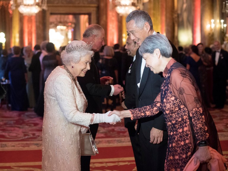 The queen in a peach coloured gown welcomes Singapore Prime Minister Lee Hsien Loong and his wife Ho Ching to Buckingham Palace in 2018