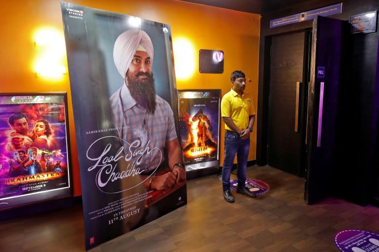 A ticket checker waits for film-goers at the gate of a cinema hall showcasing Aamir Khan-starrer "Laal Singh Chaddha", an official remake of the 1994 film "Forrest Gump" in Ahmedabad, India, August 26, 2022.