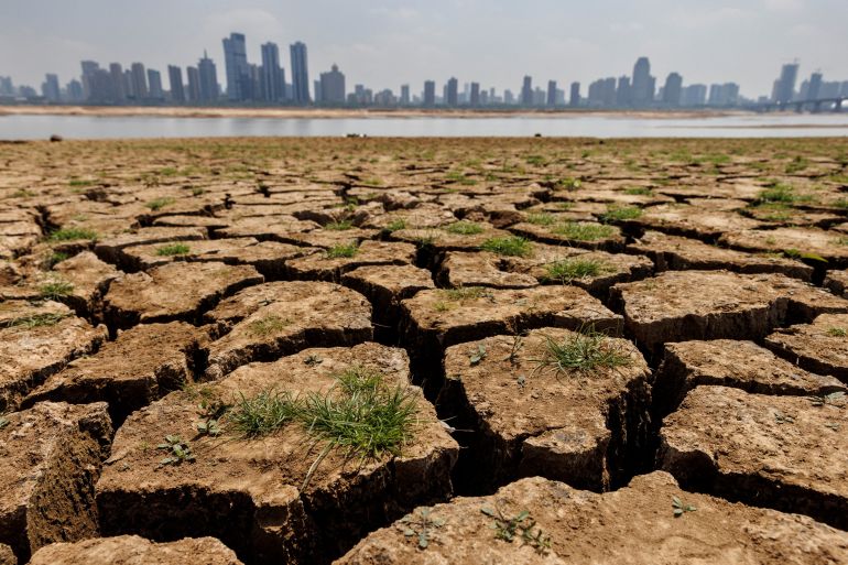 Cracks in the dried-up river bed of the Gan River, a tributary of Poyang Lake, with the Nanchang skyline behind.