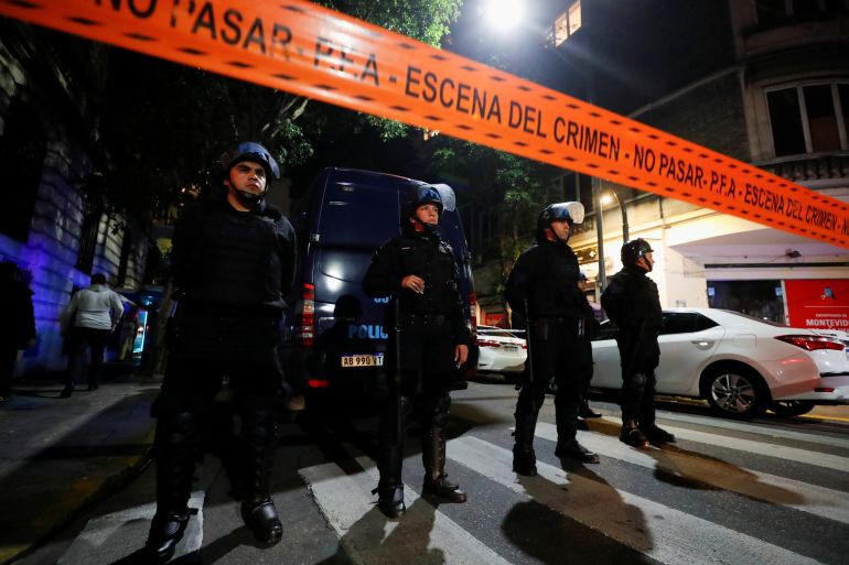 Police standing behind an orange police tape outside the house of Cristina Kirchner after a man pointed a gun at her head.