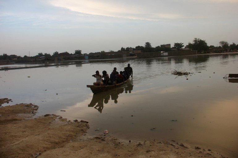Residents navigate a boat across floodwater after heavy rains in Ndjamena