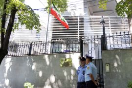 Police officers stand in front of the Embassy of the Islamic Republic of Iran in Tirana