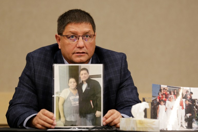 Mark Arcand, whose sister and nephew were killed in the stabbings in Saskatchewan, Canada, holds a photo of his relatives