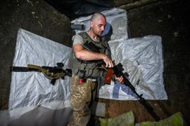 A Ukrainian service member checks his weapon