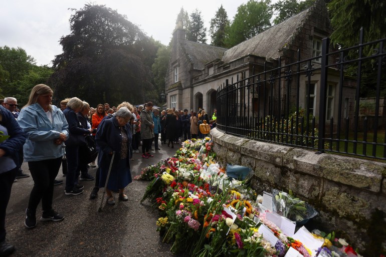 People pay respect outside the gate of Balmoral Castle, following the passing of Britain's Queen Elizabeth, in Balmoral, Scotland, Britain