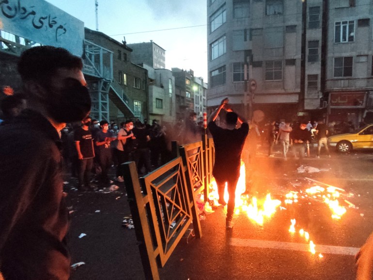 People light a fire during a protest over the death of Mahsa Amini, a woman who died after being arrested by the Islamic republic's "morality police", in Tehran, Iran September 21, 2022.