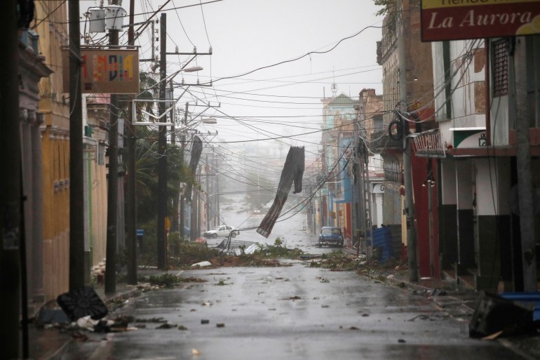 Debris on the street and hanging from cables across the street as rain continues to fall after Hurricane Ian ripped through western Cuba